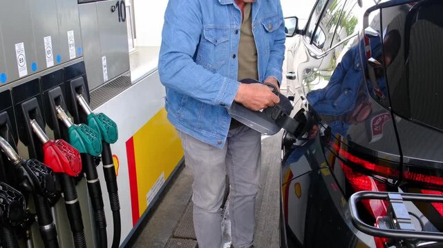 Close Up of Unrecognizable Driver Hands Opening Fuel Tank Cap at Fuel Station, Preparing Vehicle for Refueling During Rising Fuel Prices and Economic Pressure.