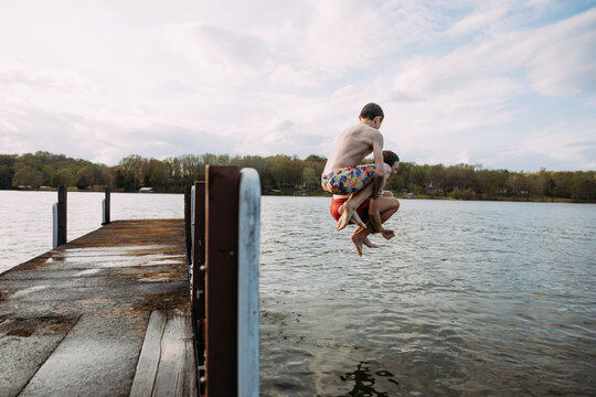 Children doing cannonball off dock during swim