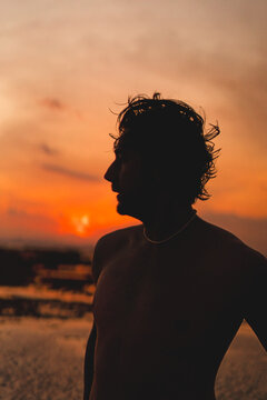Close up silhouette of young man with necklace at sunset, Bali