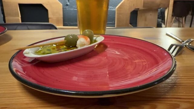 closeup view of the hand of a caucasian man enjoying spanish tapas in a bar.