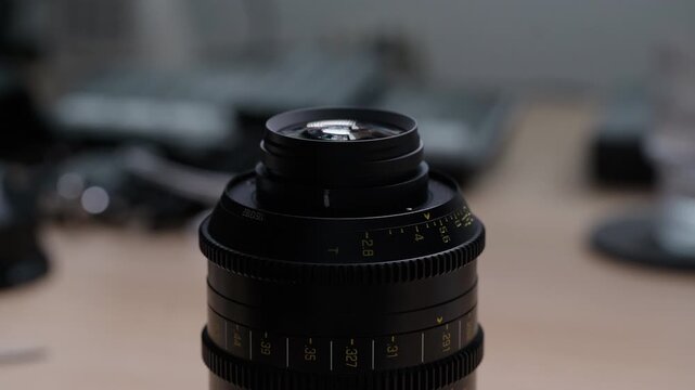 Side angle view of hands carefully placing and fitting a PL bayonet mount onto a cinema lens. Smooth and precise assembly clearly visible. Final step of an EF to PL conversion.