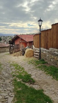 View along a narrow cobblestone lane in the traditional rural village of Zheravna, showcasing historic Bulgarian architecture and preserved cultural heritage.