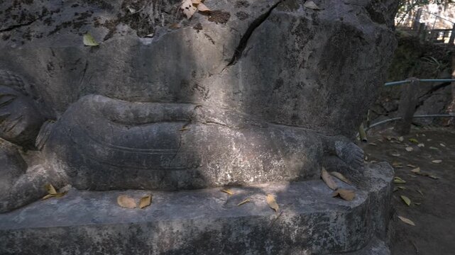 Reclining Buddha carved into stone at Dragon Cave, Laos.
