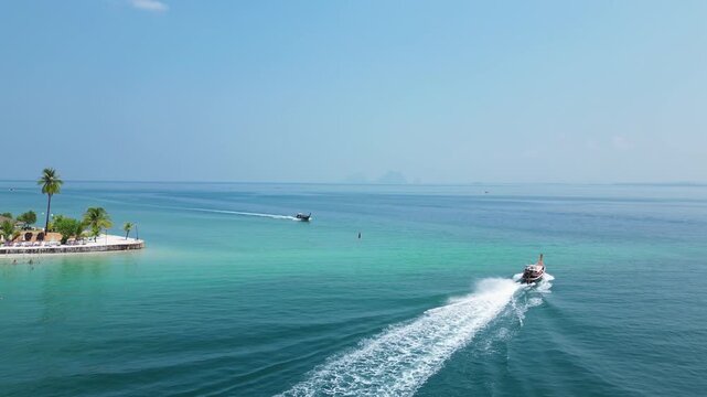 Koh Mook, Thailand: Aerial drone footage of long tail boat sailing around white sand beachfront resort of Koh Muk, an island in Andaman sea of Southern Thailand on sunny day