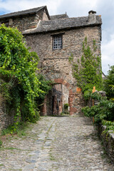 Fototapeta premium Historic cobblestone streets and medieval buildings in Conques village, Romanesque church, France