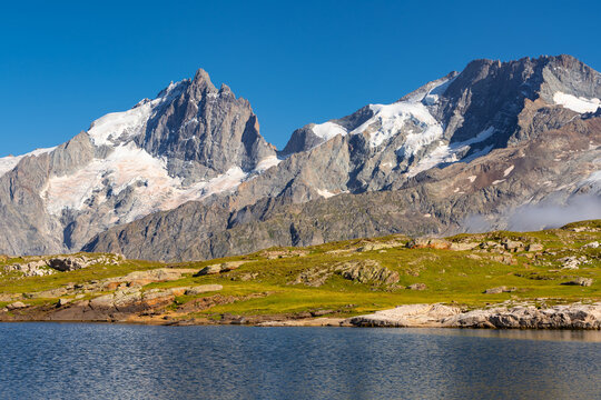 La Meije peak in Ecrins National Park in summer. View of Lac Noir lake and GR 54 hiking trail on Emparis Plateau (Oisans Massif). Hautes-Alpes, French Alps, France