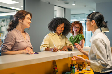 Fototapeta premium Diverse women communicating and collaborating at modern office reception