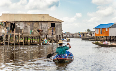 Obraz premium Fishermen in a small boat at lake Nokoué in Benin, West-Africa