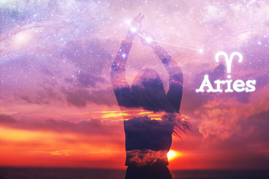 Silhouette of  young woman standing with rising hands touching stars on seashore at sunset in front of space and starry sky and aries sign. Astrology horoscope and astronomy concept.