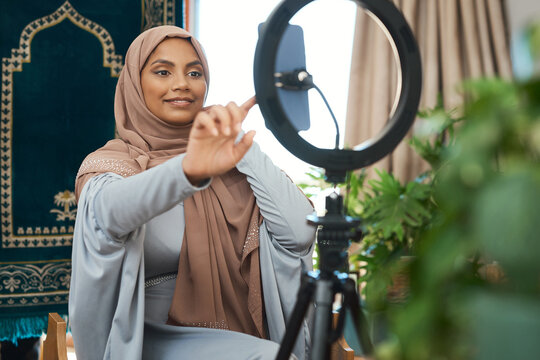 Phone, influencer and muslim woman in home for live streaming on religion, tradition or spiritual growth. Light, cellphone and islamic content creator with recording video for worship in bedroom.