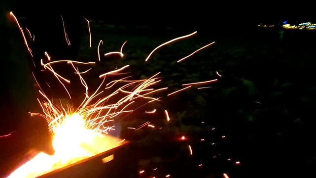 A burning fire in the dark with sparks. Orange fire with sparks. Burning wood.
