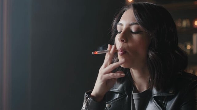 Moody portrait of a stylish woman smoking a cigarette at night, capturing a contemplative and cinematic moment in an urban setting.
