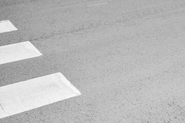 Fototapeta premium White pedestrian crossing stripes on asphalt road with clean urban minimal composition and copy space.
