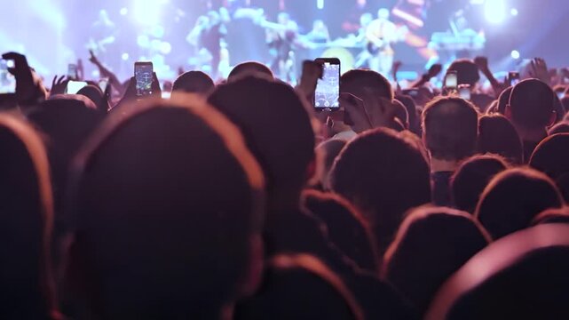 Crowd of people watching and recording a dance music concert on stage using mobile phones