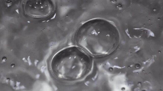 Close up of water boiling texture, water bubbles pattern, air bubbles backdrop in slow motion