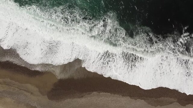 Drone flight over Mediterranean waves towards the Porto fortifications, Porto Ota, Corsica France
