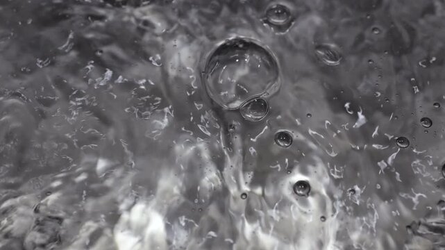 Close up of water boiling texture, water bubbles pattern, air bubbles backdrop in slow motion