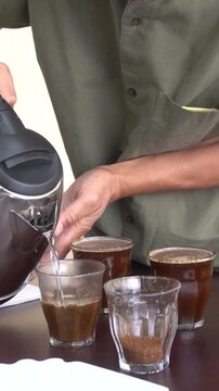 An entry-level barista currently undergoing competency training in coffee preparation