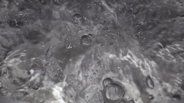 Close up of water boiling texture, water bubbles pattern, air bubbles backdrop in slow motion