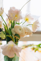 Delicate spring flowers bouquet in green vase © Iryna