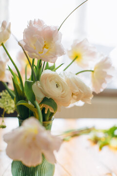 Delicate spring flowers bouquet in green vase