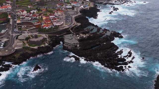 Aerial view of coastal village Madeira with rocky cliffs and crashing 