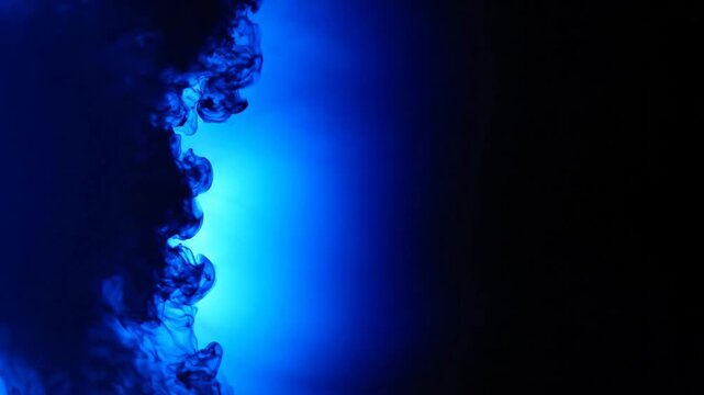 Abstract blue liquid dissolving slowly in dark water background concept