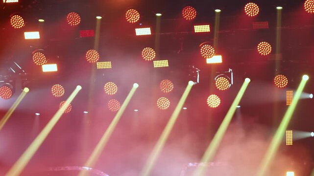 Stage lights glowing through smoke at a lively concert, creating atmosphere for dance music