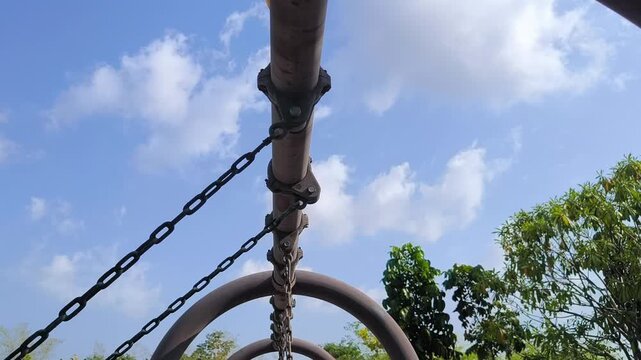 A looking up at the top crossbar of a playground swing set