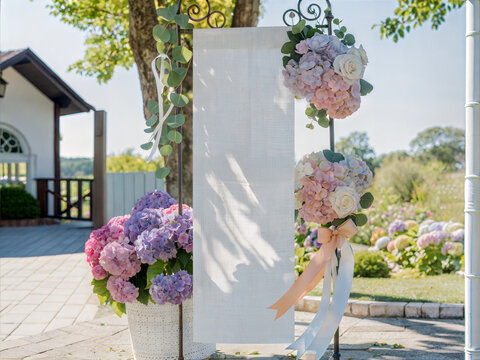 Wedding fabric banner mockup with blank white linen scroll on stand. Elegant garden ceremony decor with hydrangea flowers and eucalyptus. Outdoor welcome sign or event program template