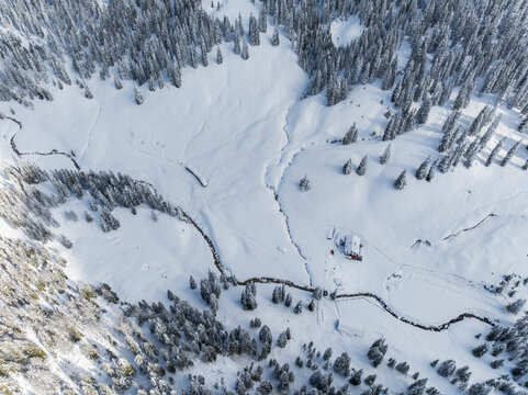 Winter landscape, aerial view of snow covered trees and R&agrave; Stua refuge in Sennes Braies Natural Park, Alto Adige, Veneto, Italy. Tourism destination.