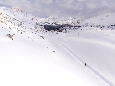 Winter landscape, skiing: A person cross-country skis on a snowy trail in a mountain landscape, travel and outdoor lifestyle concept. Sennes refuge,Sennes Braies Natural Park,Alto Adige,Veneto,Italy