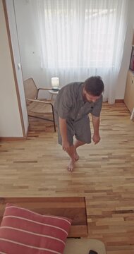 A man demonstrates a stretching routine at home using a foam roller. This video highlights self-care and muscle recovery practices, promoting wellness and physical health.