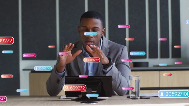 Presenter gesturing at incoming digital badges, manipulating tablet to highlight business data