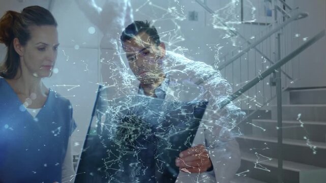 Clinician holding radiograph, overlay animating, colleague entering, both leaning, reviewing film