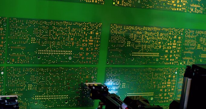 Modern Production of electronic circuit boards. Digital technological production of motherboards on CNC machine. Close-up of robotic equipment in high-tech production. PCB assembly.