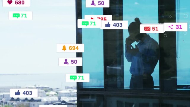 Exec holding phone by blue glass, tracking social media badges incoming from left overlapping him