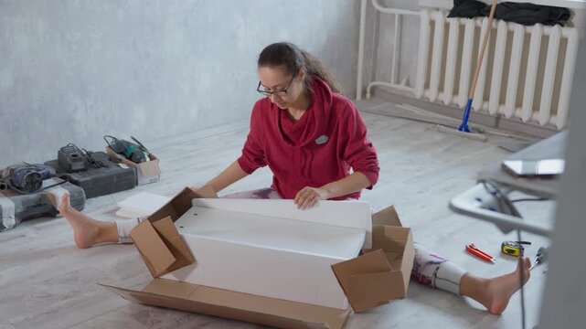 Solo Installer Organizes Room With Tools. Woman Independently Arranges Furniture In Empty Area. Determined Woman In Vacant Room Carefully Assembling And Positioning Furniture Alone