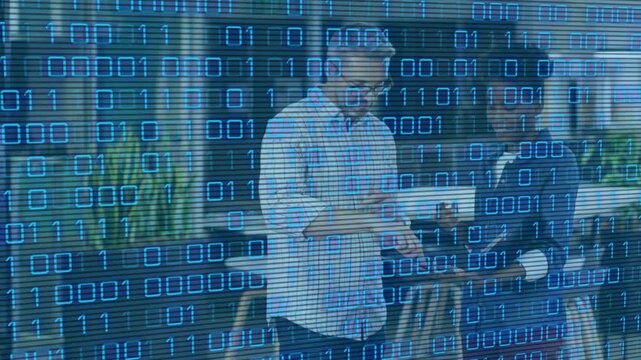 Man gesturing while woman tapping tablet, initiating binary overlay in office atrium showing data