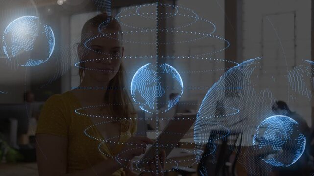 Raising tablet, yellow-top woman tapping, scrolling at office, moving blue dotted globes for data