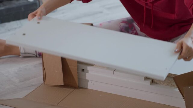 Woman Arranges Furniture. Woman Meticulously Arranging And Organizing Various Pieces Of Furniture. Female Handler Carefully Sorts And Arranges Different Furniture Panels And Components Methodically