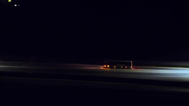Bus driving on road at night, headlights lighting way. Passenger coach moving through darkness, lights illuminating path. Public transport traveling along nighttime street, beams guiding direction