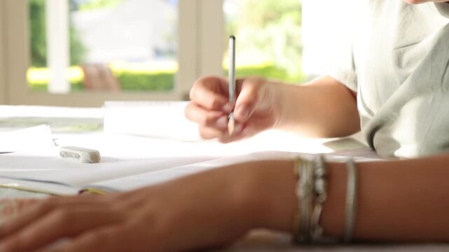 close up of boys hand holding pencil doing homework