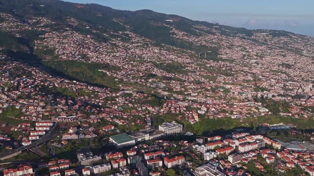 Aerial view of Funchal cityscape nestled in Madeira mountains with res
