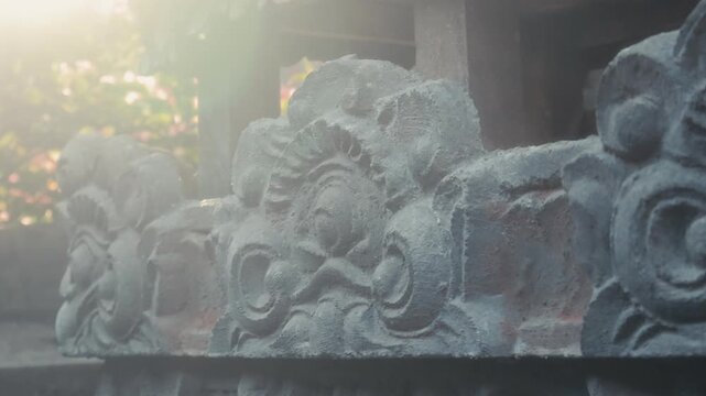 Close up detail of traditional Balinese stone carving ornament with push in and pull out camera movement, capturing ancient architectural texture.