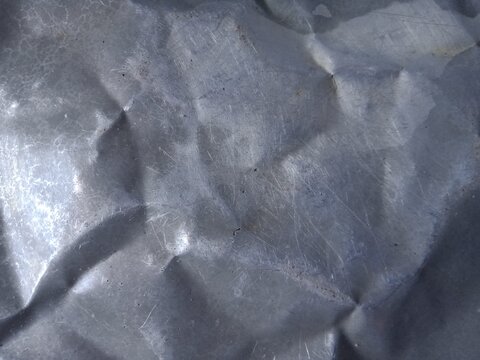 Close up photo of Dented Aluminium Plate as a grunge background.