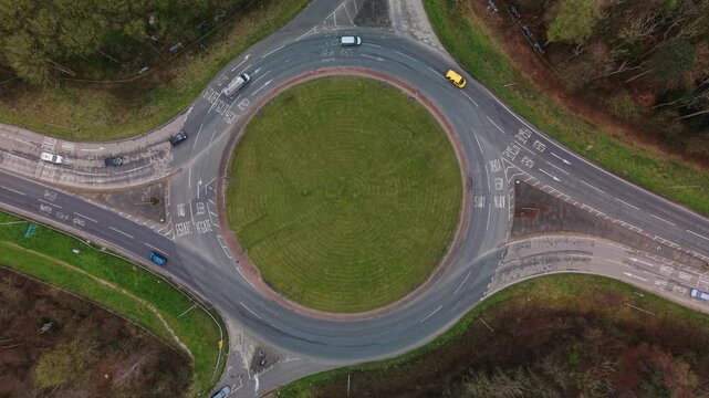 Birds eye view of cars driving around a roundabout with multiple exits and cars showing traffic flow to ease congestion