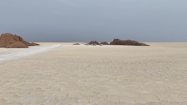 Aerial shot of 4x4 vehicles stopped in open desert landscape getting ready to continue the journey