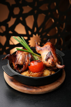 Whole Roasted Quail with Golden Potatoes and Grilled Tomato.