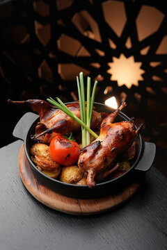 Whole Roasted Quail with Golden Potatoes and Grilled Tomato.